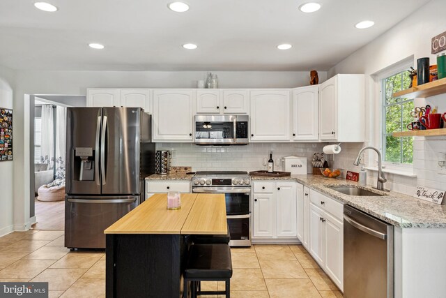 kitchen with white cabinetry, tasteful backsplash, appliances with stainless steel finishes, and a sink