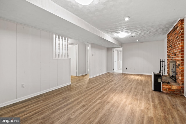 5420 Well Spring Rd, La Plata, MD 20646 - finished basement with baseboards, wood finished floors, a brick fireplace, and a textured ceiling
