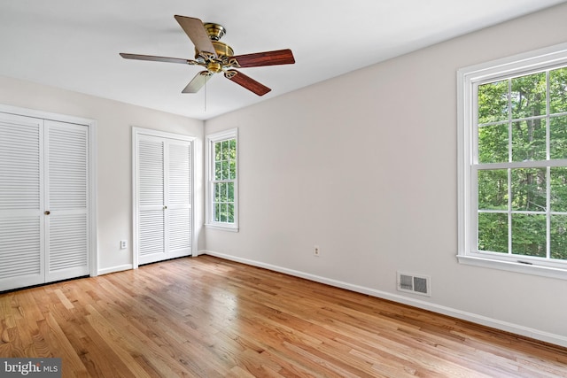 5420 Well Spring Rd, La Plata, MD 20646 - unfurnished bedroom featuring two closets, baseboards, light wood-style flooring, and ceiling fan