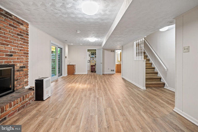 5420 Well Spring Rd, La Plata, MD 20646 - unfurnished living room featuring baseboards, light wood finished floors, stairs, a textured ceiling, and a fireplace