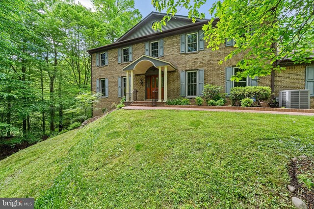 5420 Well Spring Rd, La Plata, MD 20646 - colonial-style house featuring cooling unit, brick siding, and a front lawn
