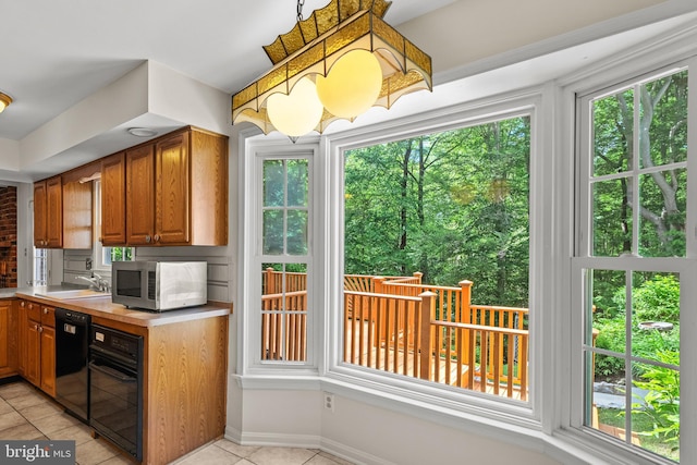 5420 Well Spring Rd, La Plata, MD 20646 - kitchen featuring black appliances, light tile patterned floors, light countertops, brown cabinetry, and a sink