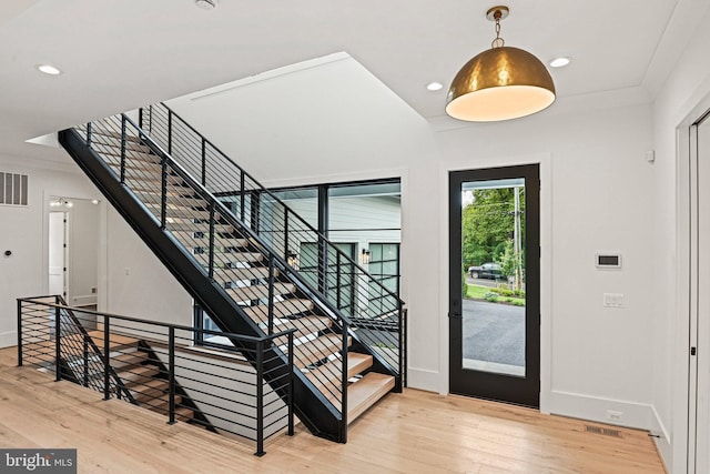 foyer with wood finished floors, recessed lighting, visible vents, and stairs