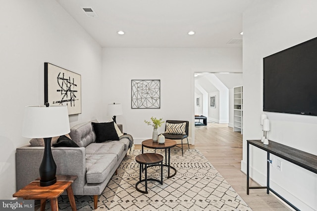 living area featuring visible vents, light wood-type flooring, recessed lighting, and baseboards