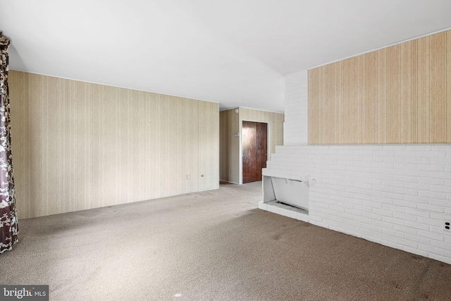 unfurnished living room featuring carpet and wallpapered walls