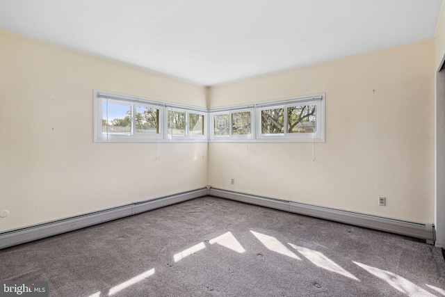 empty room featuring plenty of natural light, baseboard heating, and carpet floors
