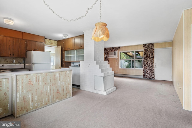 kitchen with light colored carpet, decorative backsplash, a wall unit AC, and freestanding refrigerator