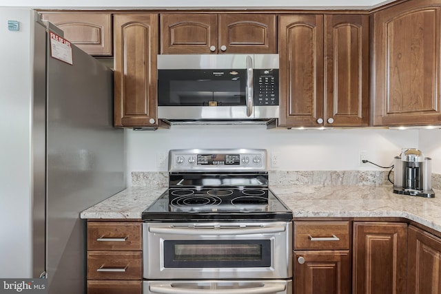 kitchen featuring appliances with stainless steel finishes and light stone countertops