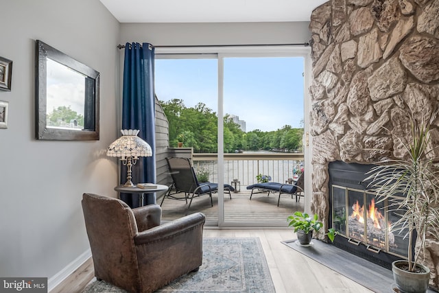 sitting room featuring a fireplace, wood finished floors, and healthy amount of natural light