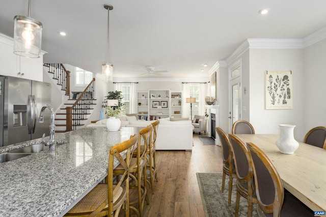 dining space featuring crown molding, ceiling fan, dark wood finished floors, stairs, and recessed lighting