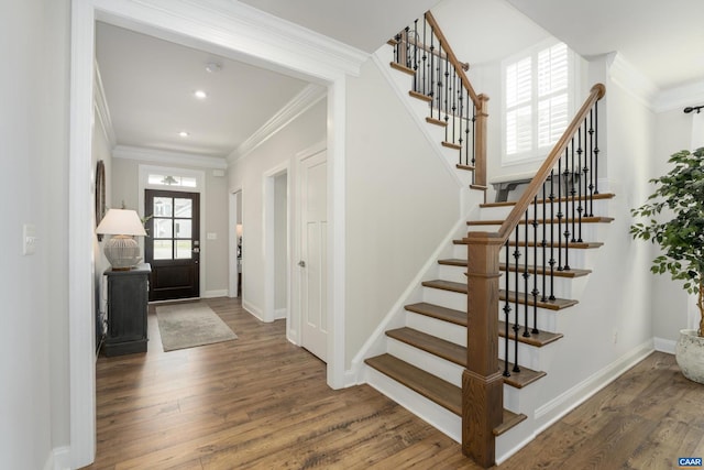 foyer entrance with crown molding, baseboards, stairs, and wood finished floors