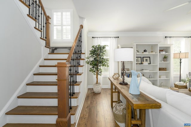 stairway featuring crown molding and hardwood / wood-style floors