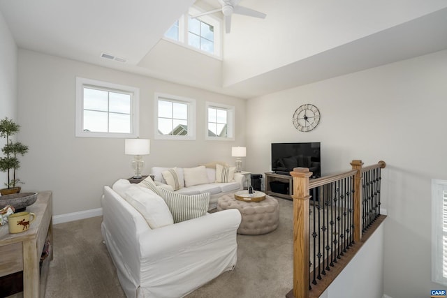 living area featuring ceiling fan, visible vents, baseboards, and carpet