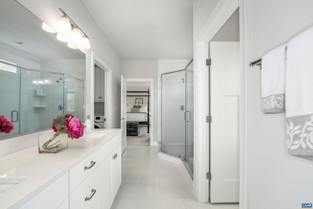 ensuite bathroom with ensuite bathroom, double vanity, a stall shower, and tile patterned floors