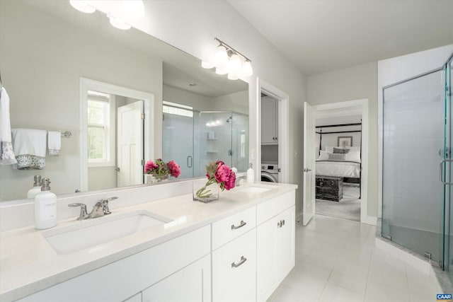ensuite bathroom featuring a sink, tile patterned floors, a stall shower, and double vanity