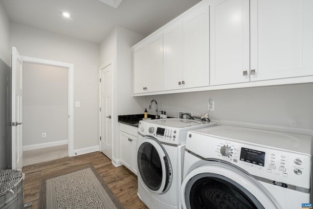 washroom featuring dark wood-style flooring, cabinet space, baseboards, recessed lighting, and washer and clothes dryer