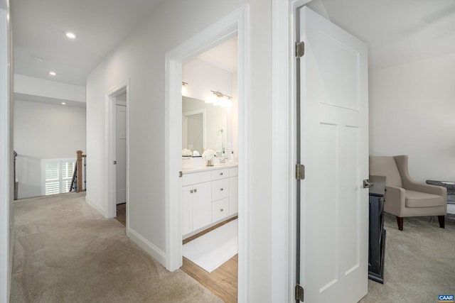 hall featuring recessed lighting, baseboards, and light colored carpet