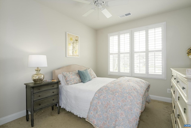 bedroom with baseboards, visible vents, light carpet, and ceiling fan
