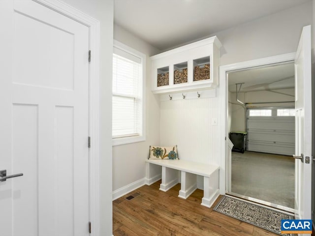 mudroom with baseboards, visible vents, and wood finished floors