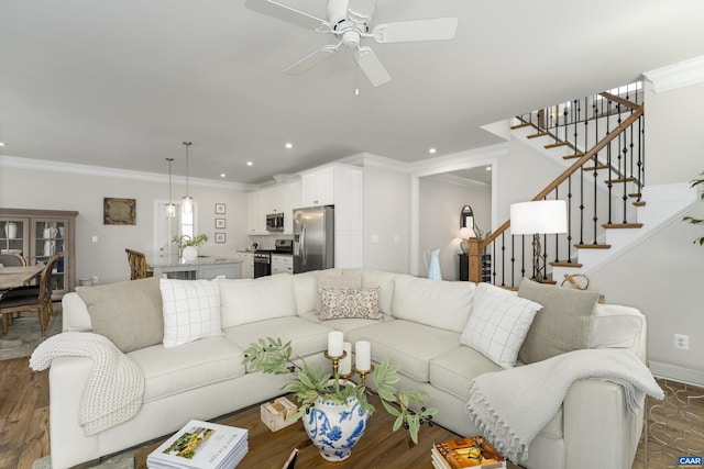 living area with dark wood-style flooring, ceiling fan, recessed lighting, ornamental molding, and stairway