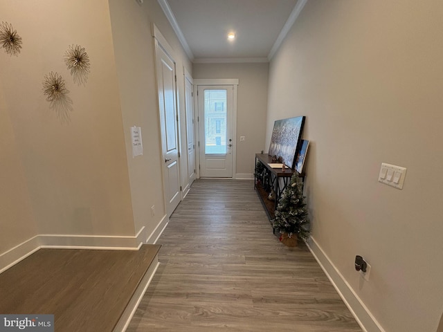 doorway to outside with baseboards, wood finished floors, and ornamental molding