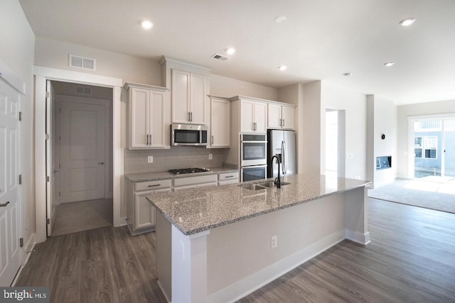 kitchen featuring white cabinets, visible vents, dark wood-style flooring, and appliances with stainless steel finishes