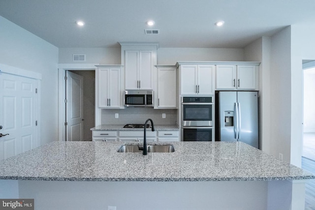 kitchen featuring white cabinetry, visible vents, stainless steel appliances, and a sink
