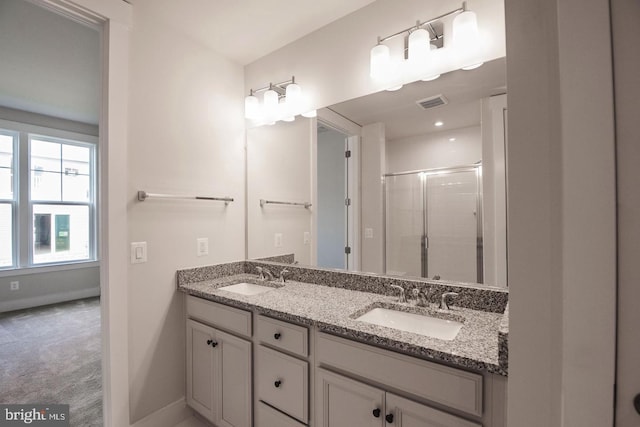 full bath with baseboards, visible vents, a shower stall, and a sink