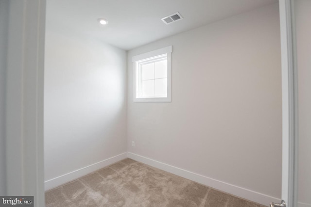empty room with light colored carpet, visible vents, recessed lighting, and baseboards