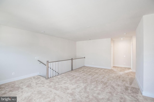 unfurnished room with light colored carpet and baseboards
