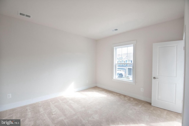 carpeted spare room with baseboards and visible vents