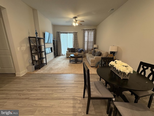 dining room featuring visible vents, ceiling fan, light wood-style flooring, and baseboards