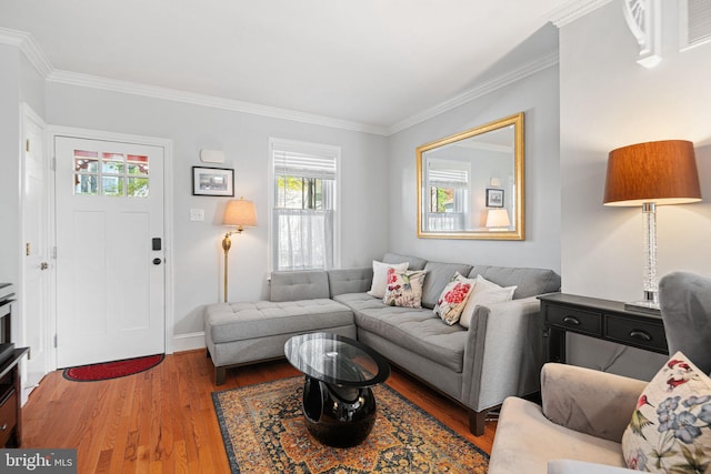 living room with crown molding, baseboards, and wood finished floors