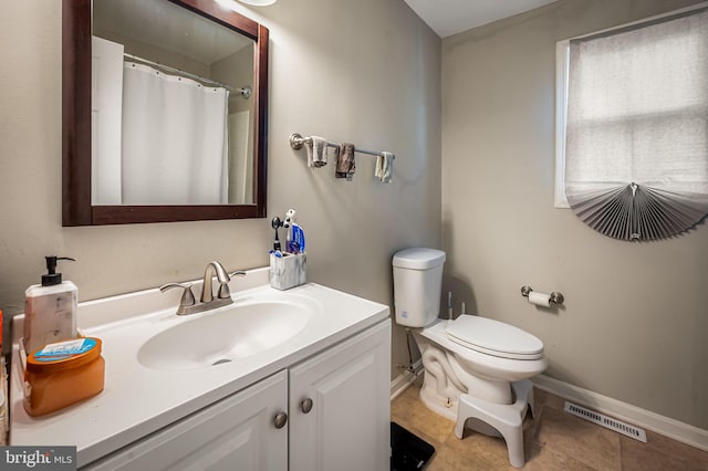 bathroom with vanity, toilet, visible vents, baseboards, and tile patterned flooring
