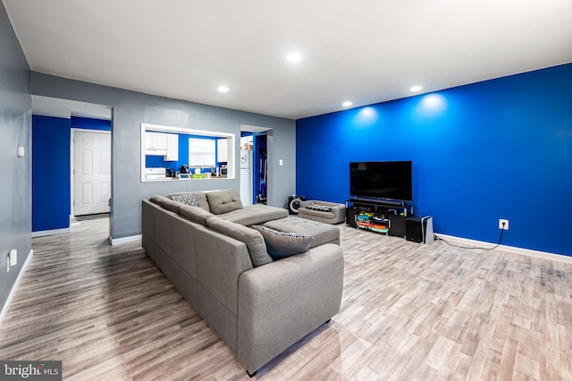 living room with baseboards, recessed lighting, and light wood finished floors