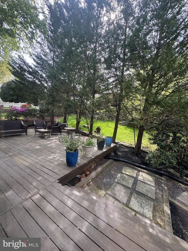 wooden terrace featuring a lawn