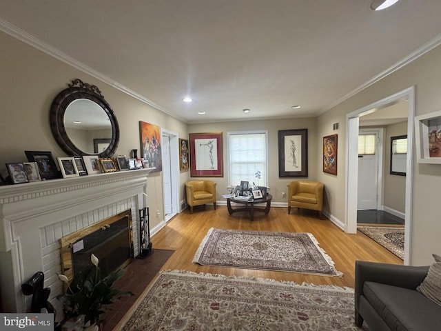living area featuring wood finished floors, a tiled fireplace, recessed lighting, and ornamental molding