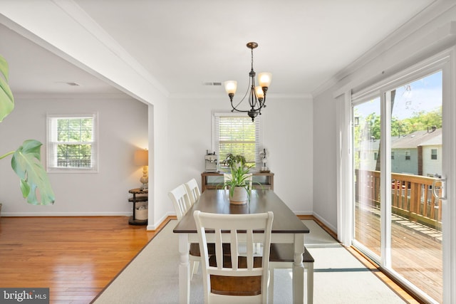 dining room featuring crown molding, visible vents, a healthy amount of sunlight, and light wood-type flooring