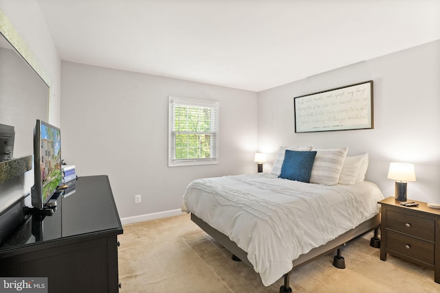 bedroom with baseboards and light colored carpet