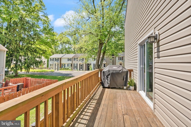 wooden deck featuring a residential view and a grill
