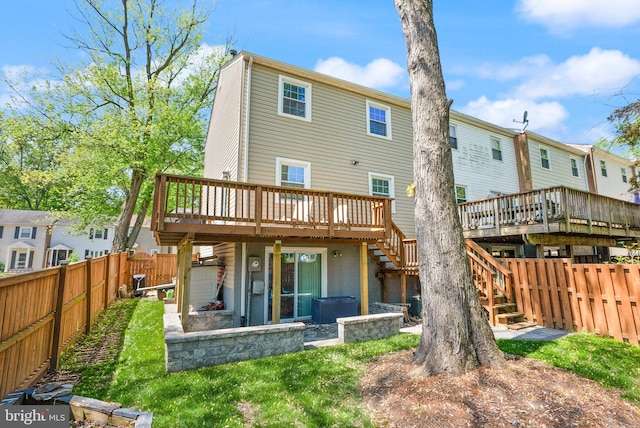 back of property featuring a fenced backyard, a wooden deck, and stairway