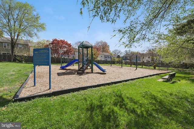 community play area with a lawn and fence
