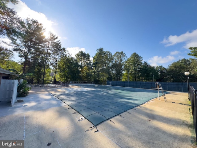 community pool with fence and a patio