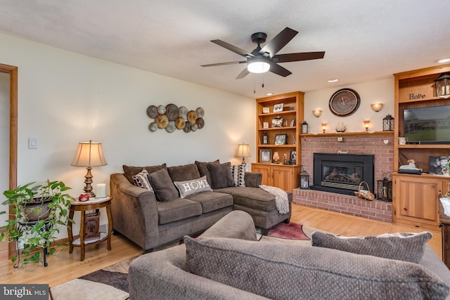 1085 Greenwood Rd, Winchester, VA 22602 - living area with wood finished floors, a ceiling fan, and a brick fireplace