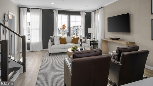 living room featuring stairway, wood finished floors, crown molding, and baseboards