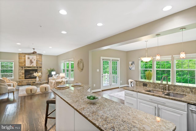 6725 Accipiter Dr, New Market, MD 21774 - kitchen featuring white cabinetry, wood finished floors, light stone countertops, and a sink