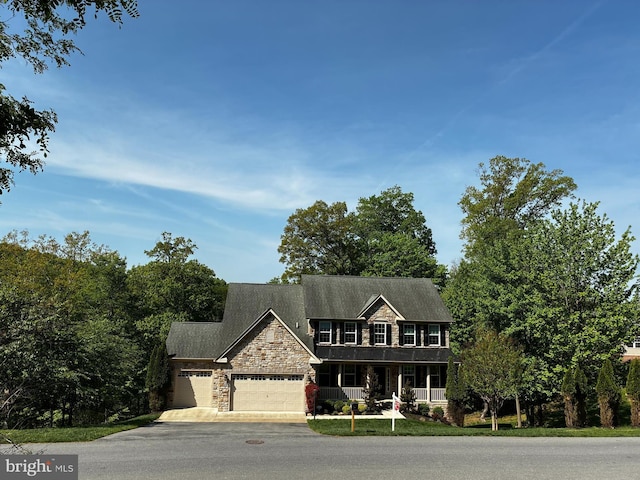 6725 Accipiter Dr, New Market, MD 21774 - craftsman-style house with concrete driveway, stone siding, a porch, and an attached garage
