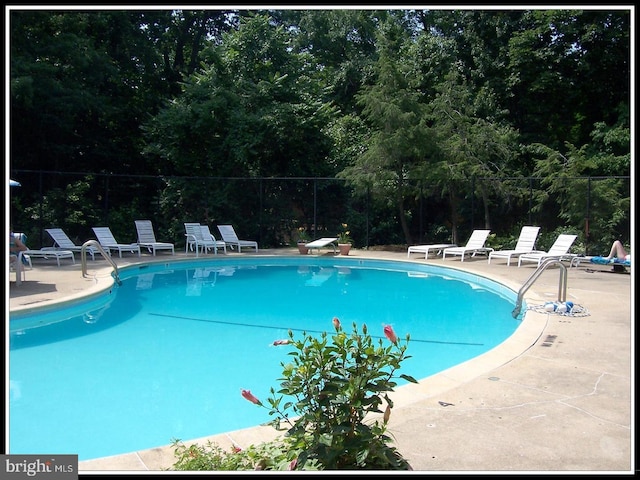 pool featuring fence and a patio area
