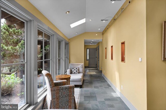 hall featuring recessed lighting, baseboards, a wealth of natural light, and lofted ceiling with skylight
