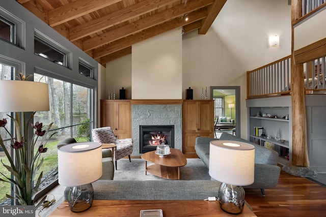 living area featuring a fireplace, wood finished floors, wooden ceiling, high vaulted ceiling, and beamed ceiling